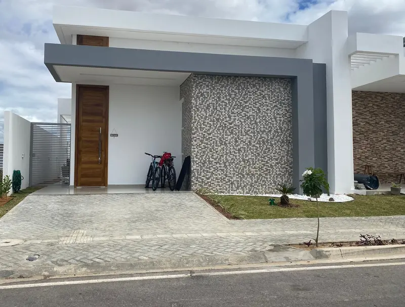 Casa térrea concluída com volume em pedra e porta de madeira