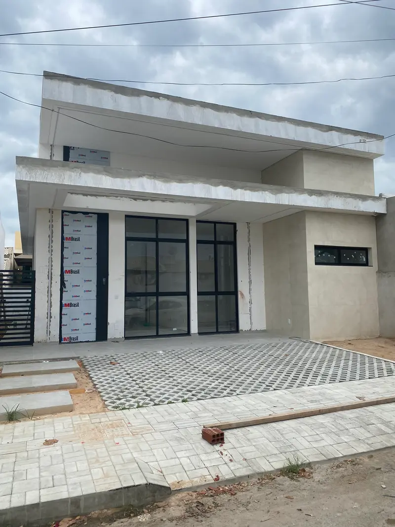 Foto da casa térrea com marquise e esquadrias pretas na reta final da obra