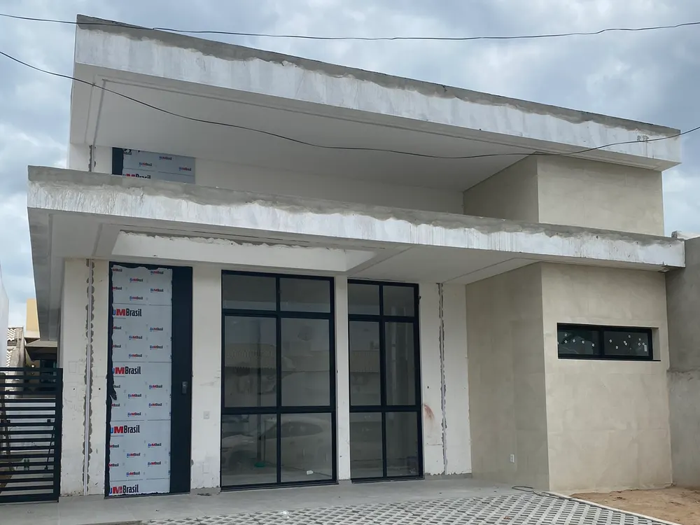 Foto da casa térrea com marquise e esquadrias pretas na reta final da obra