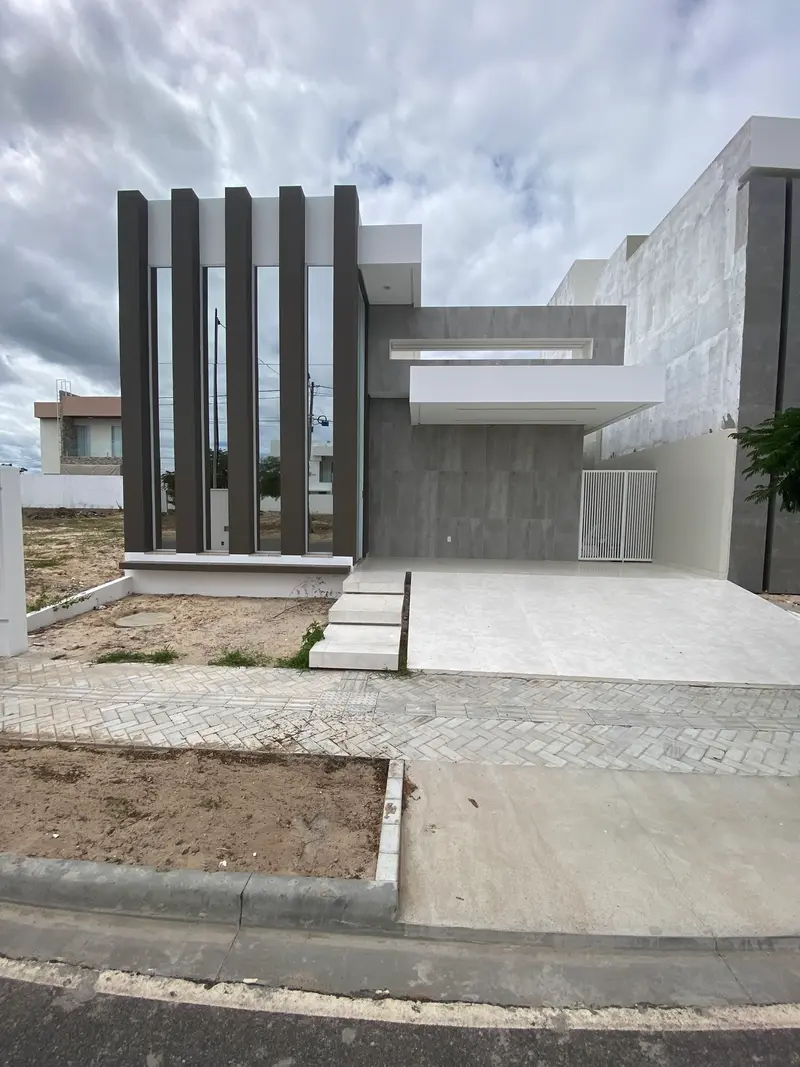 Foto da casa construída, com aletas verticais e marquise