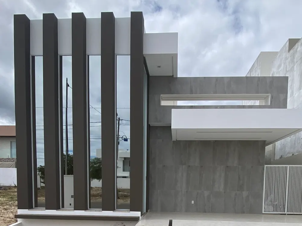 Foto da casa construída, com aletas verticais e marquise